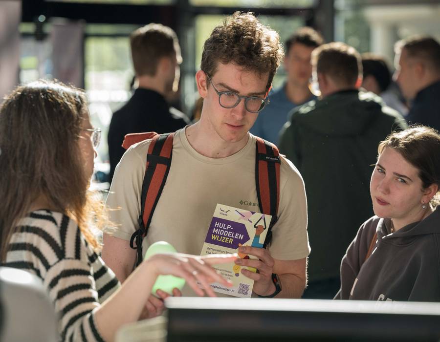 Student leest een folder over hulpmiddelen